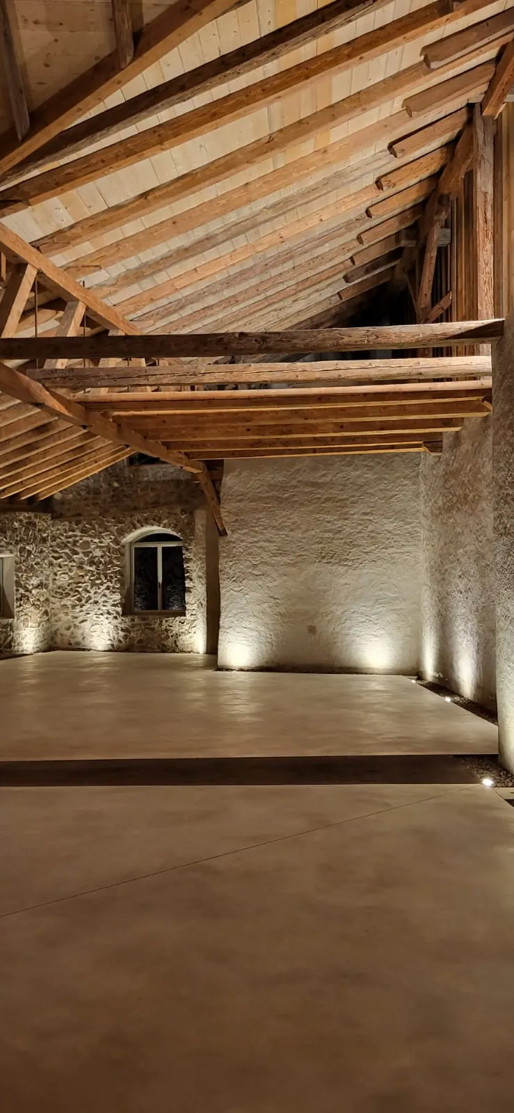 Saal unter offenem Dachstuhl, Natursteinmauern von Bodeneinbauleuchten gestreift, Schloss Payersberg.